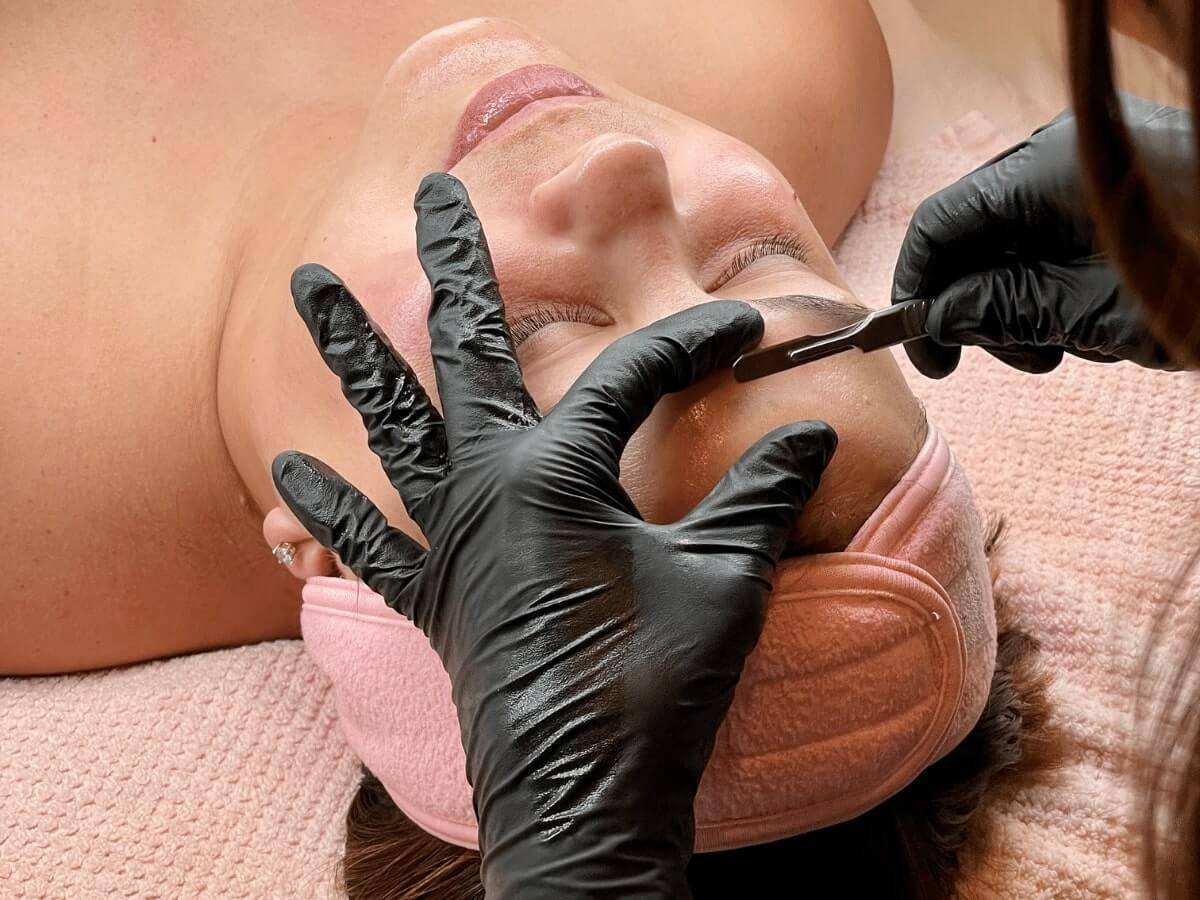 A client receiving a dermaplane facial treatment